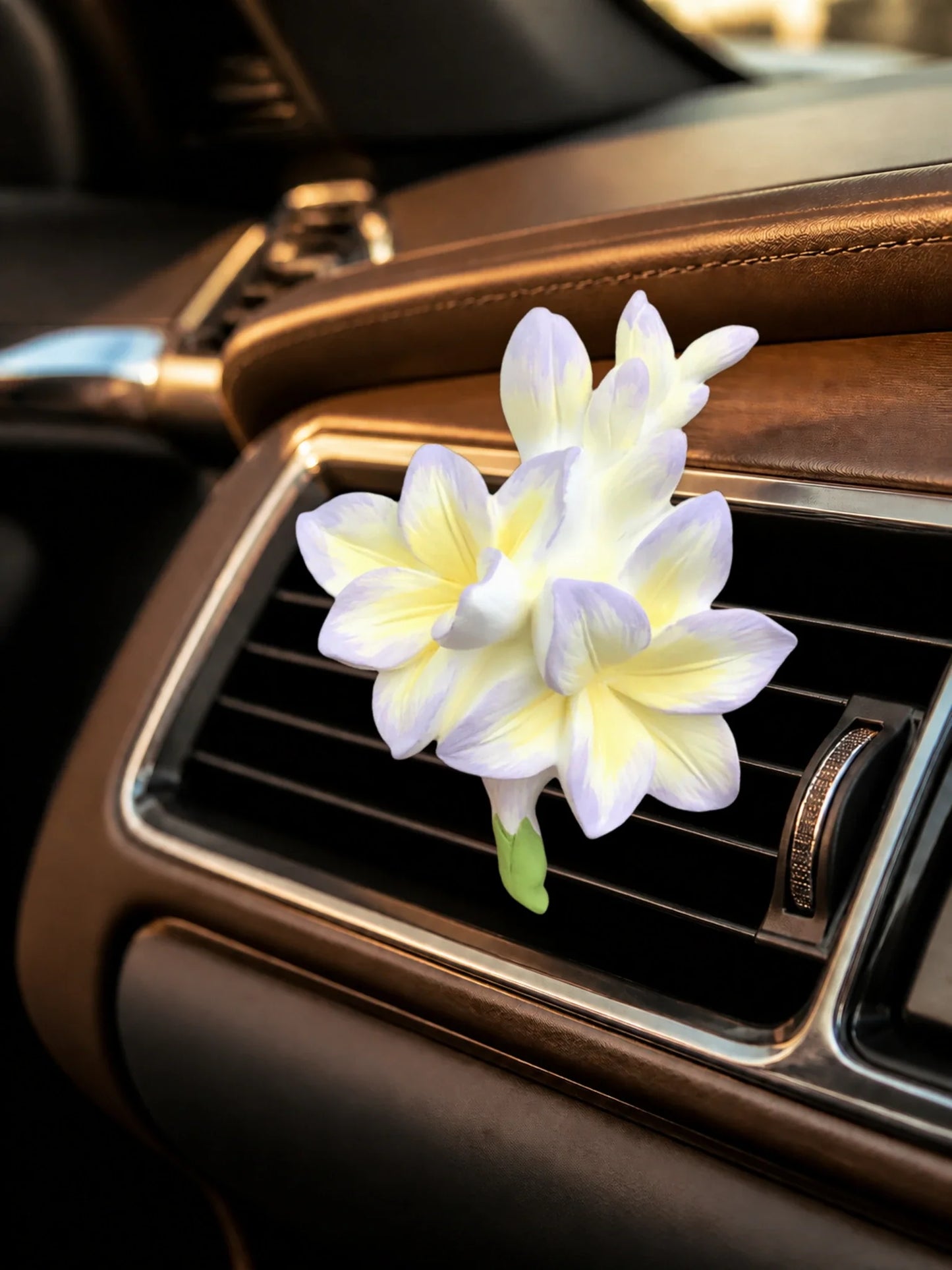 Lavender Cream Freesia ornament installed squarely on a second horizontal car vent