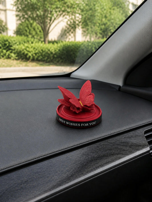 Burgundy Butterfly Dashboard Ornament resting on a vehicle dashboard in daylight