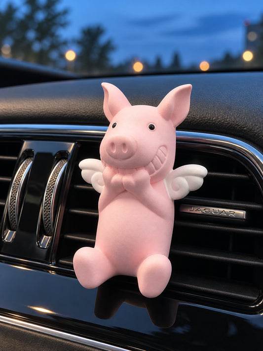One pink angel-wing Wish Pig in front of a Jaguar center air vent at blue hour