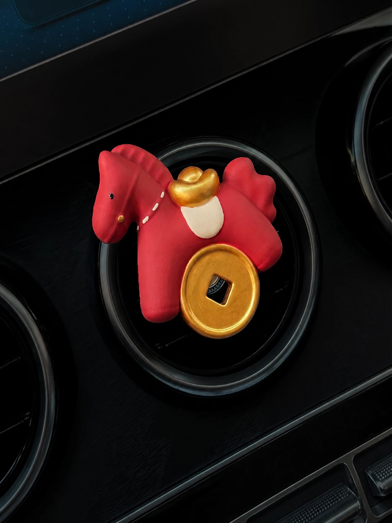 Scarlet Horse with gold ingot and round coin mounted squarely on a circular car vent