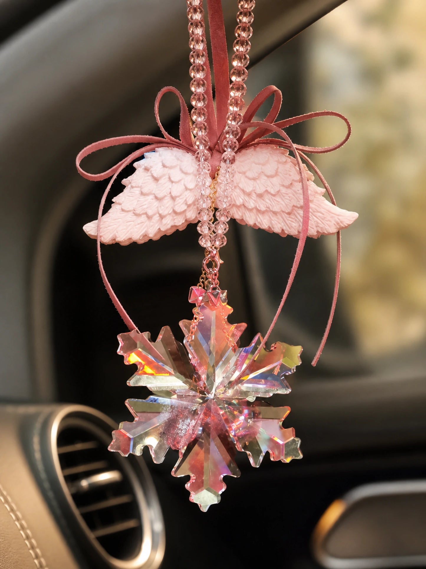 Textured wing, ribbon, cord, and faceted pendant detail