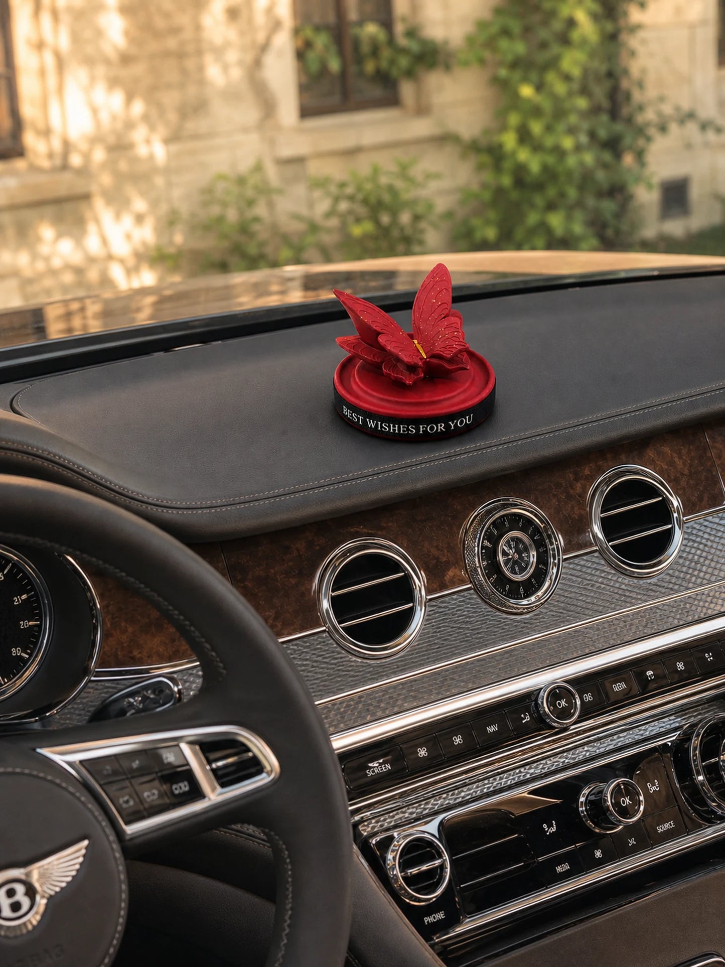 Burgundy Butterfly Dashboard Ornament placed on a Bentley dashboard