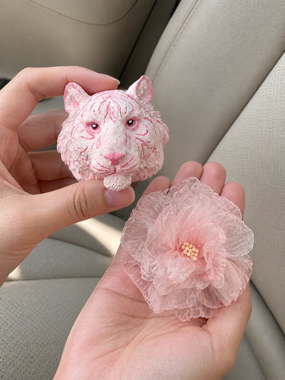 Blush Tiger and Rose car vent charms shown at hand scale