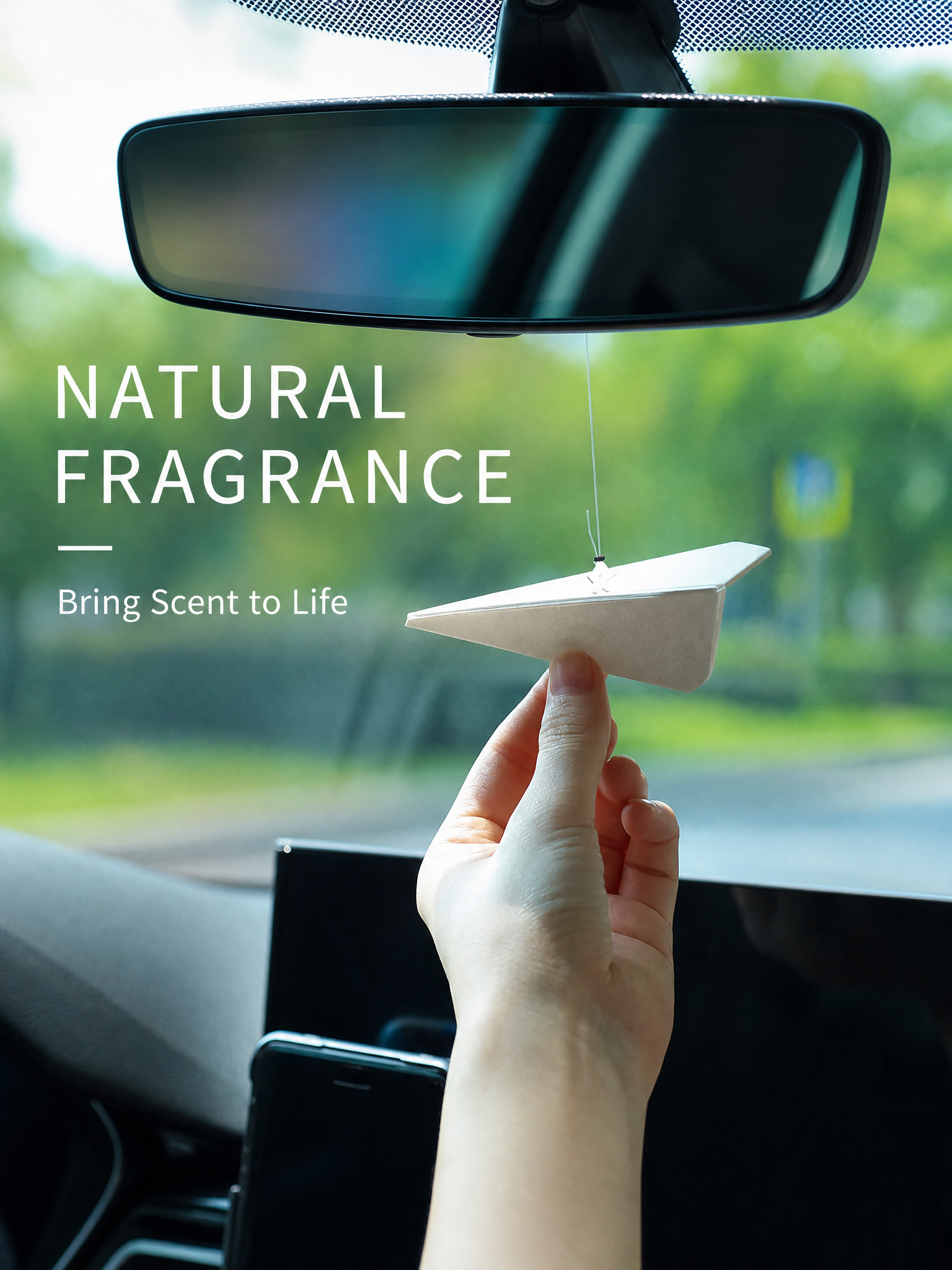 Hand holding origami paper plane diffuser in car