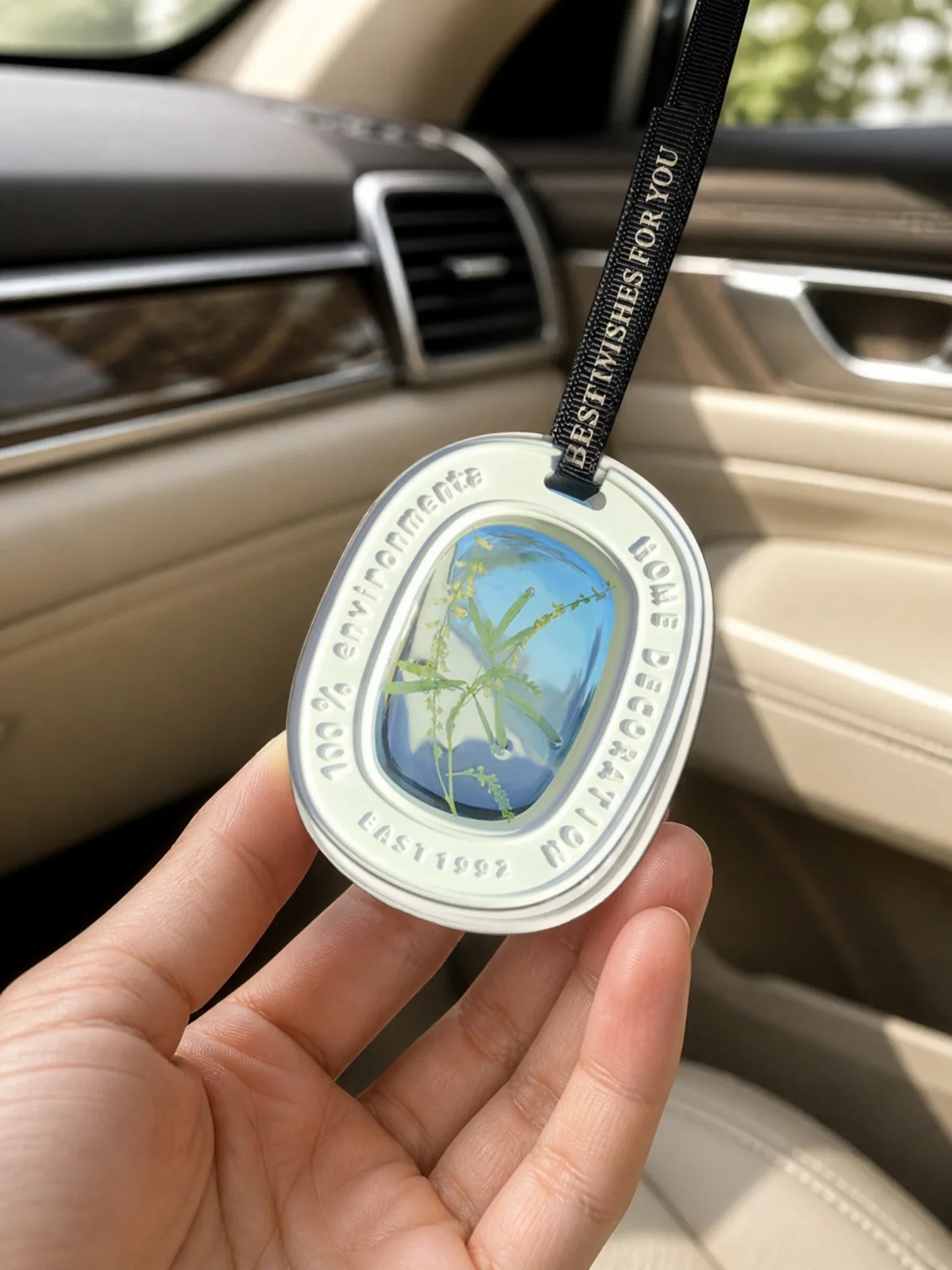 Botanical Green window car charm shown in hand for scale