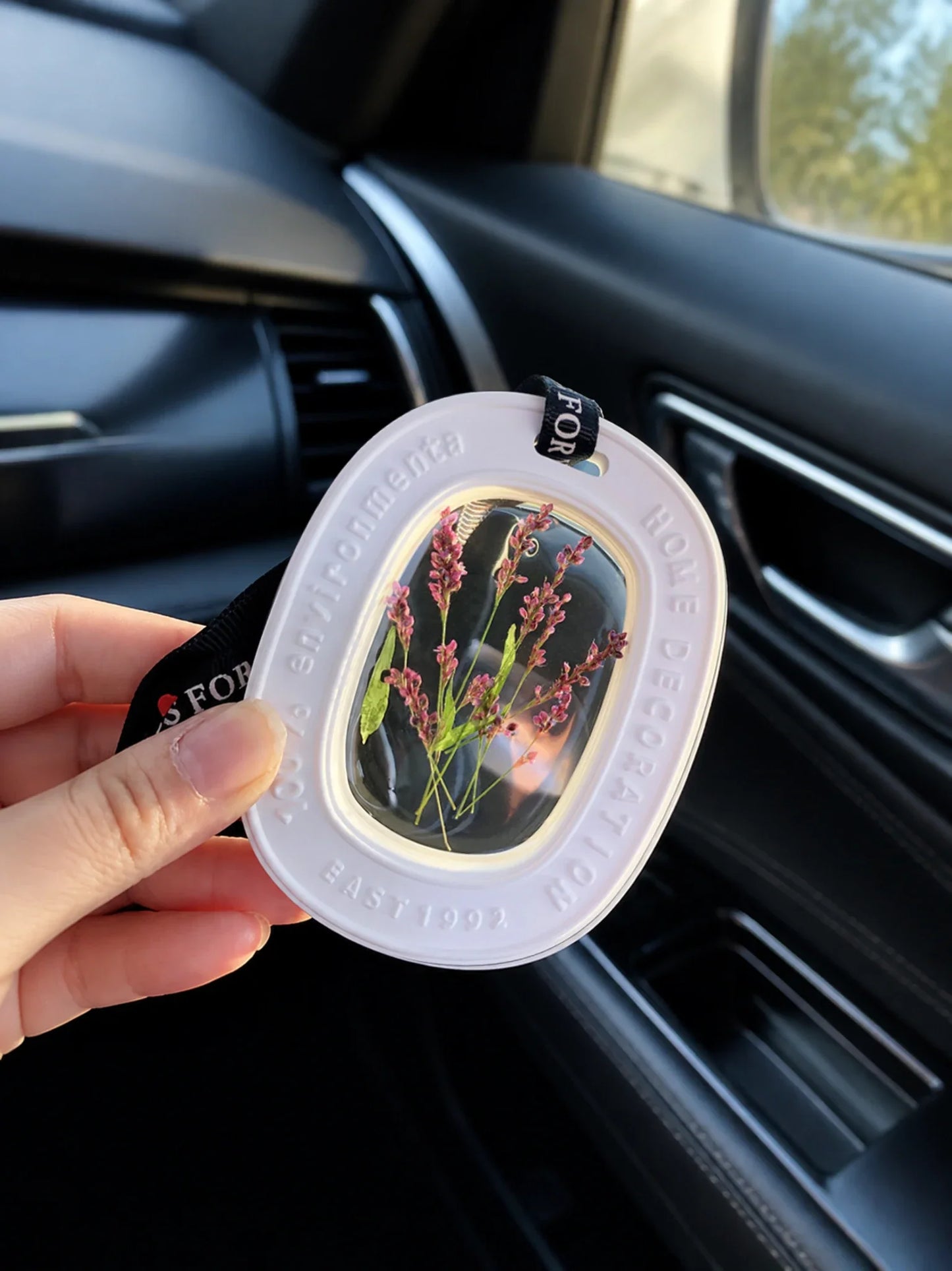 Heather Purple botanical window car charm shown in hand for scale