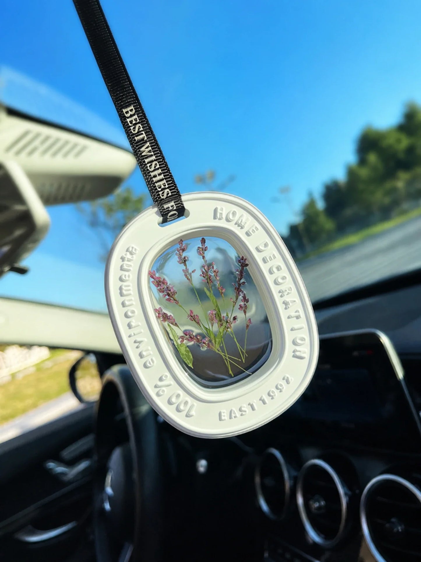 Heather Purple botanical window car charm suspended naturally beneath a rearview mirror