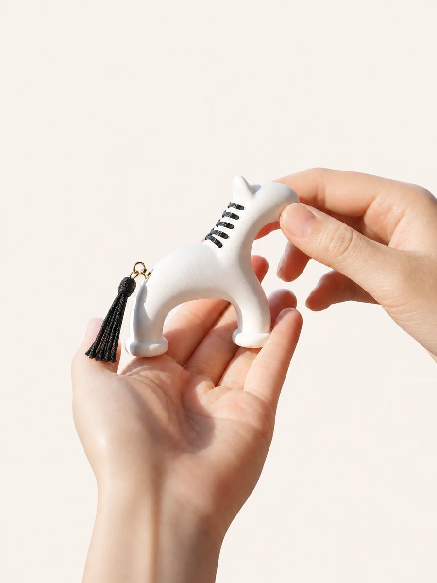Hand holding pony natural gypsum diffuser on clean white background