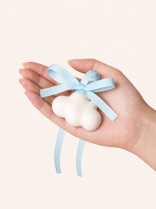 Hand holding white cloud gypsum air freshener with light blue ribbon