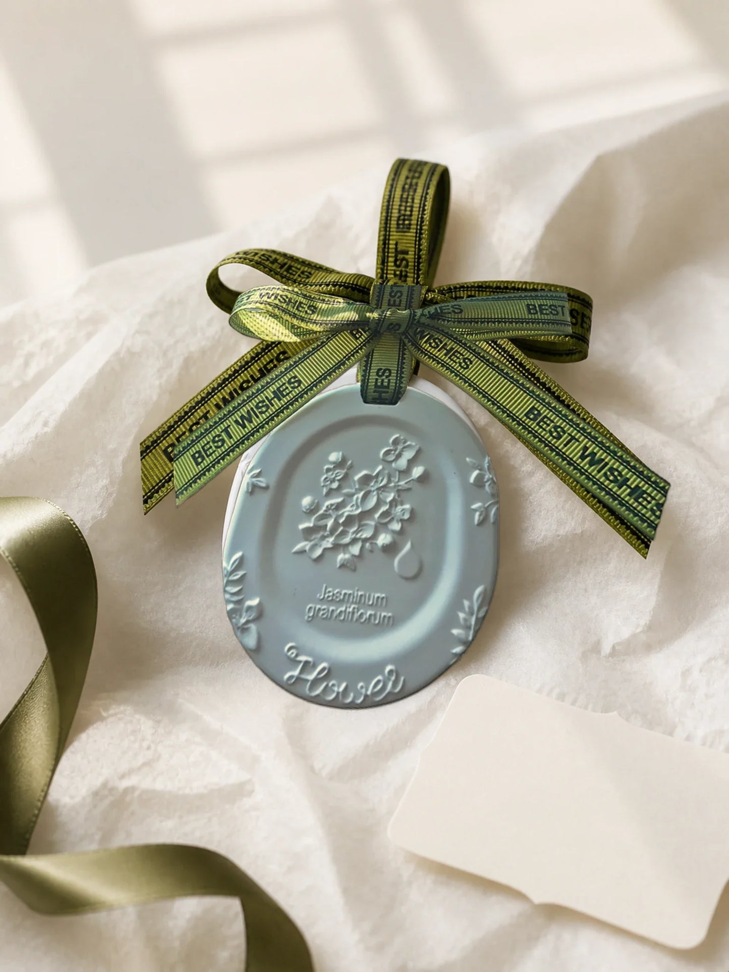 White Jasmine medallion charm presented with neutral tissue and ribbon for gifting inspiration
