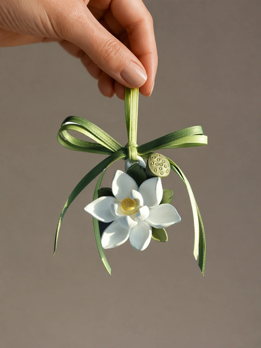 Lotus Serenity hanging car charm shown in hand for an honest sense of scale
