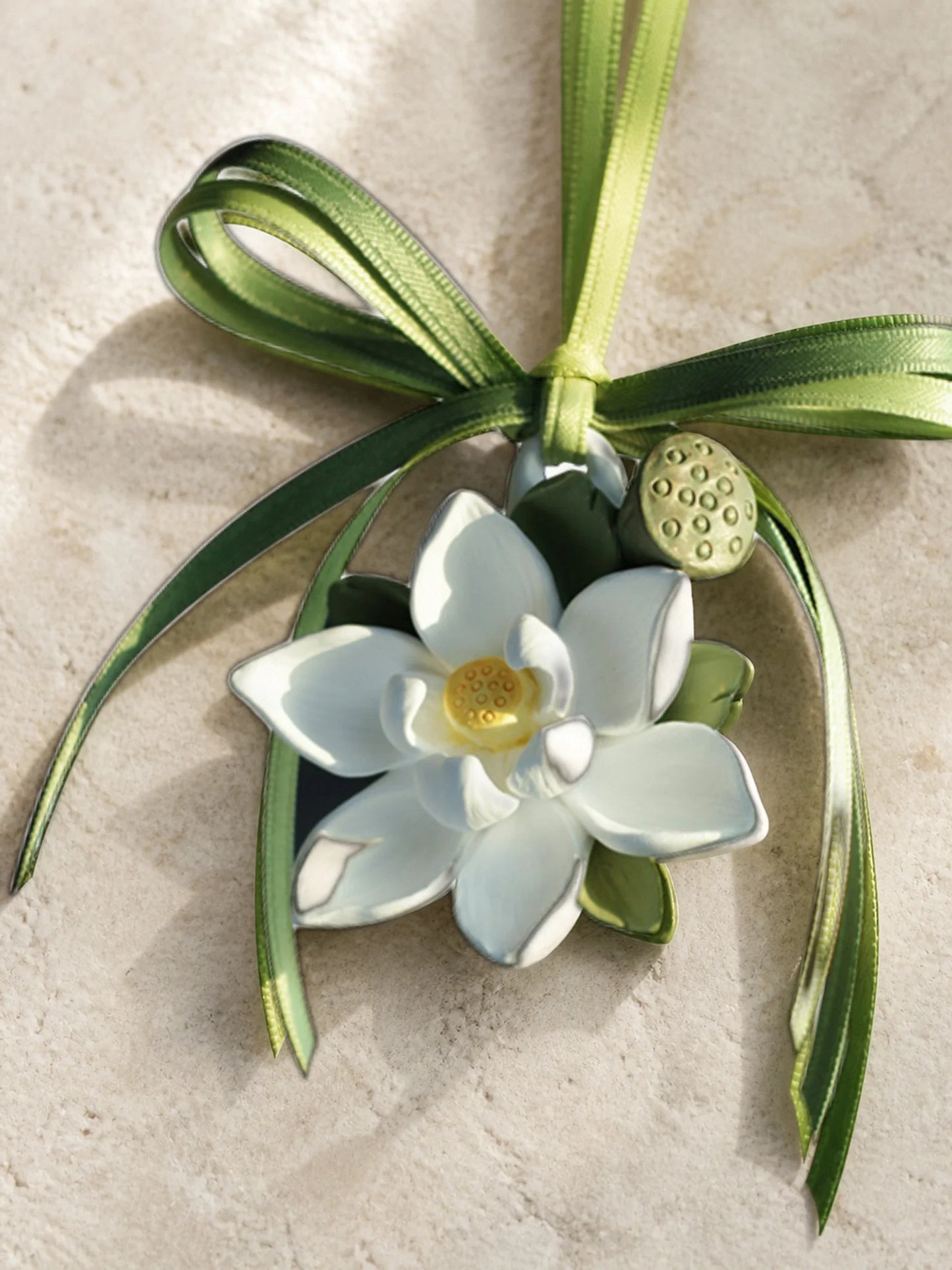 Close view of layered white lotus petals, olive leaves and sculpted lotus pod