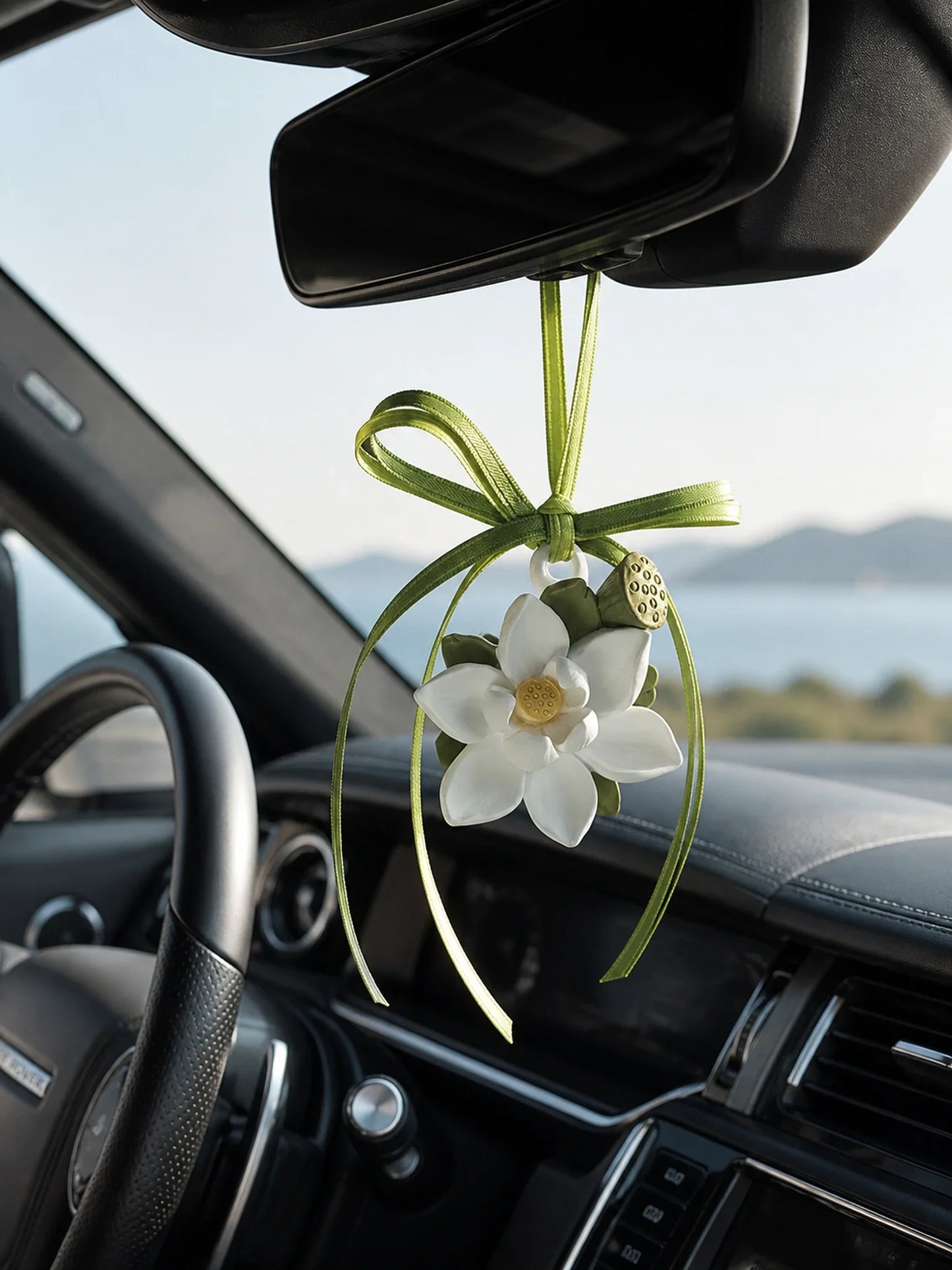 Lotus Serenity hanging car charm suspended beneath a Range Rover rearview mirror