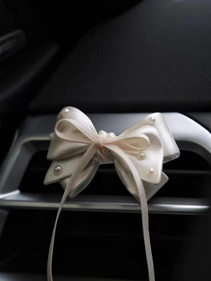 Pearl White Bow car vent ornament clipped to an air vent