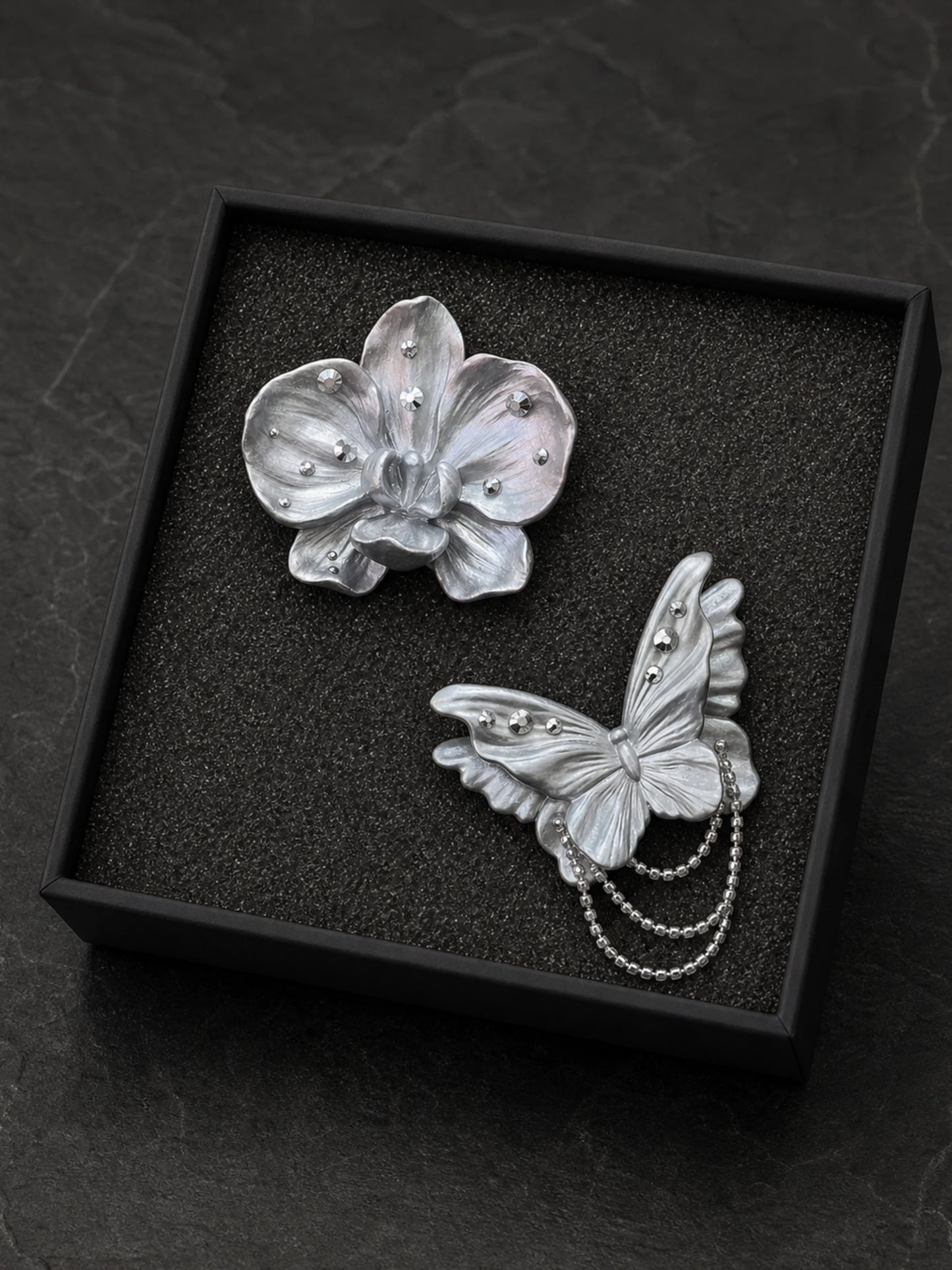 Butterfly and orchid gift set arranged in its black presentation box with a flush foam insert