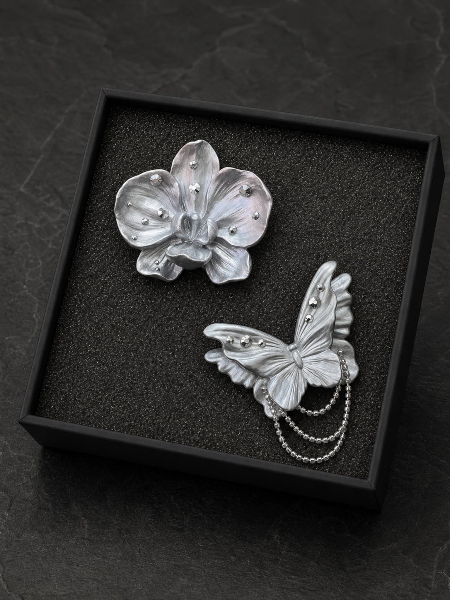 Butterfly and orchid gift set arranged in its black presentation box with a flush foam insert