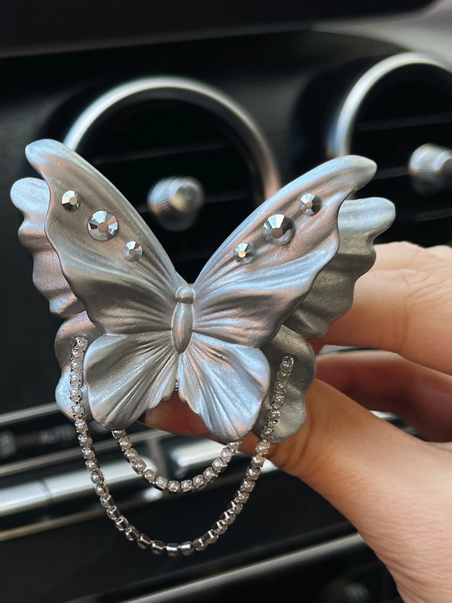 Pearl silver butterfly ornament held in hand for scale