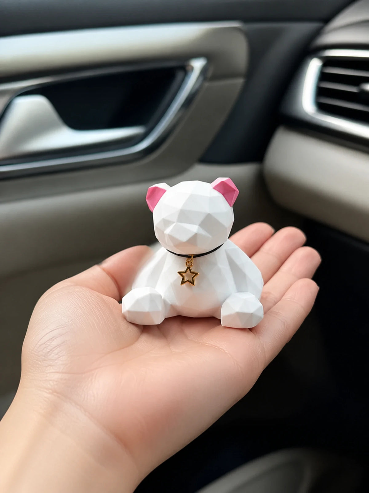 Rose Ear faceted bear dashboard ornament shown in hand for scale