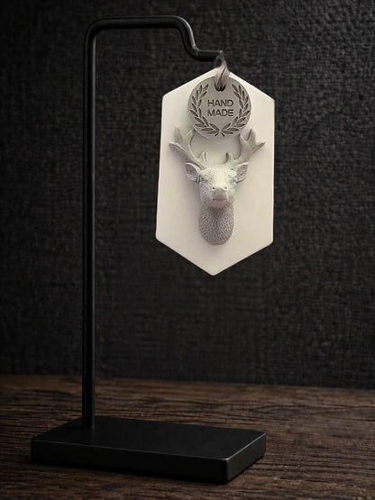 Complete white-plaque gray stag ornament on a black display stand