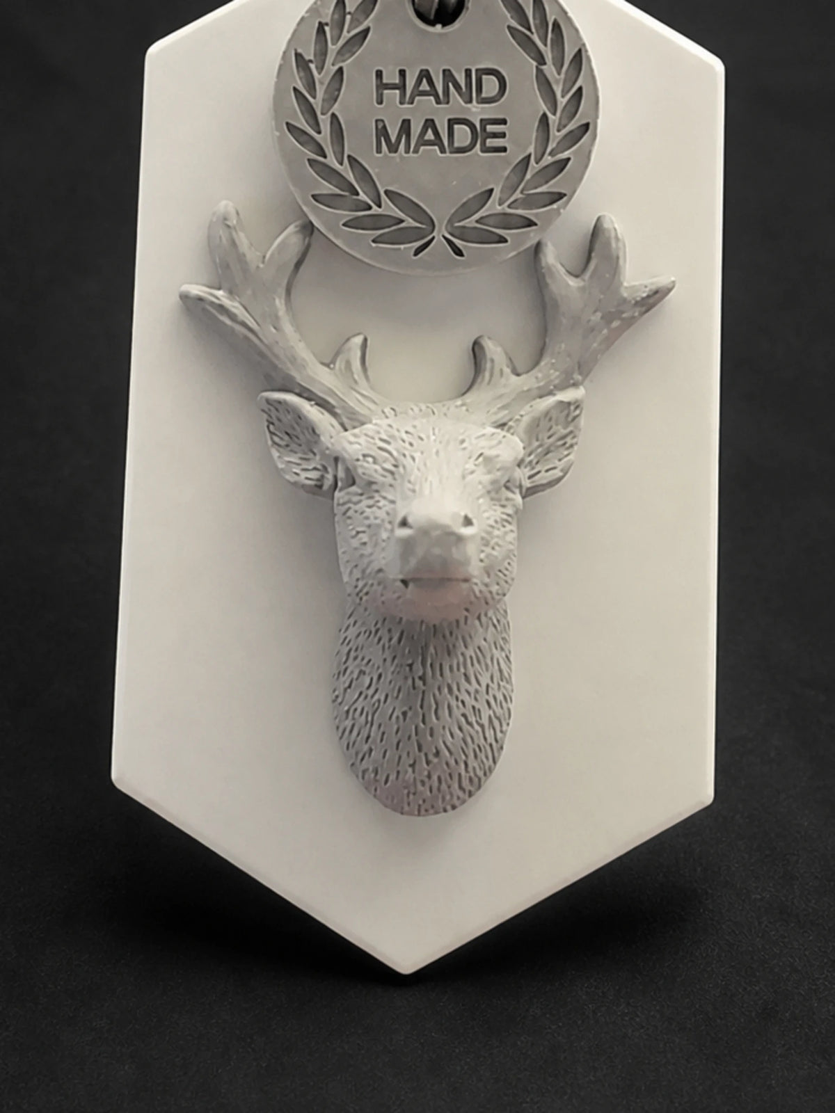 Close detail of the raised stag head, antlers and textured neck relief