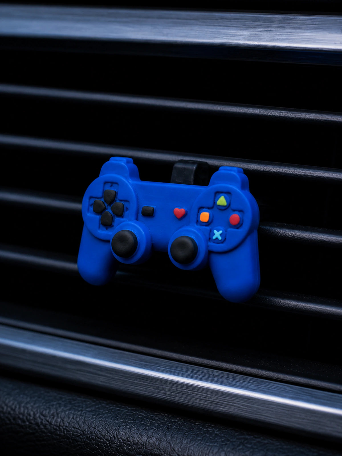 Retro game controller vent ornament in a blue-hour car interior