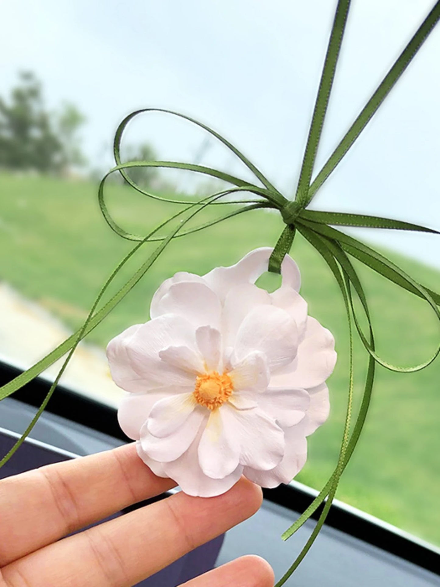 Ivory peony charm with a golden center and olive ribbon