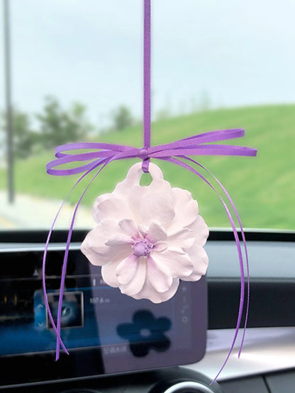 Ivory peony charm with a lavender center and purple ribbon