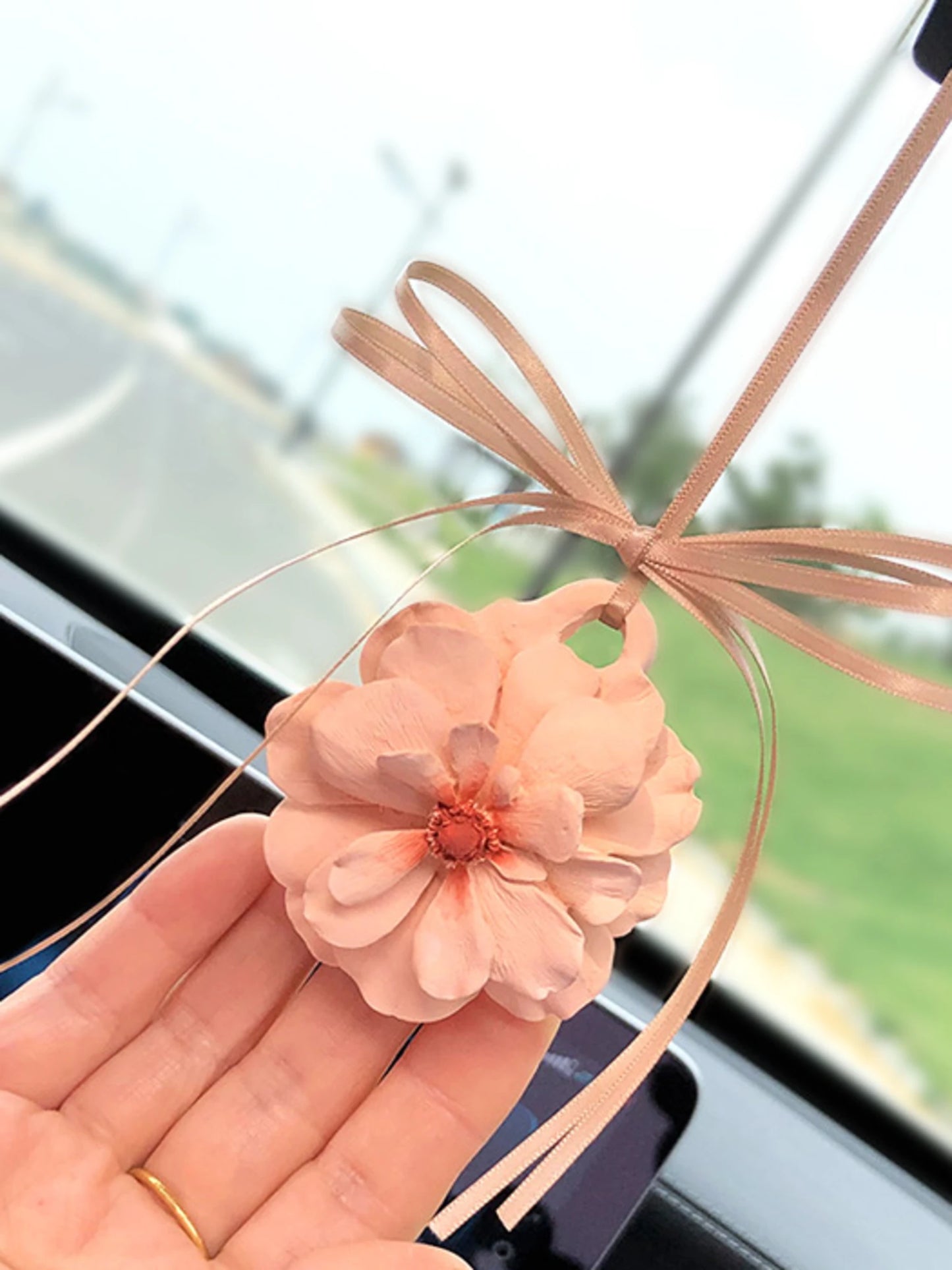 Champagne peony charm with a coral center and peach ribbon