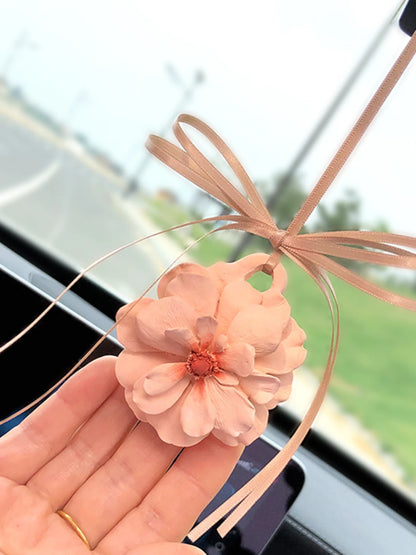 Champagne peony charm with a coral center and peach ribbon