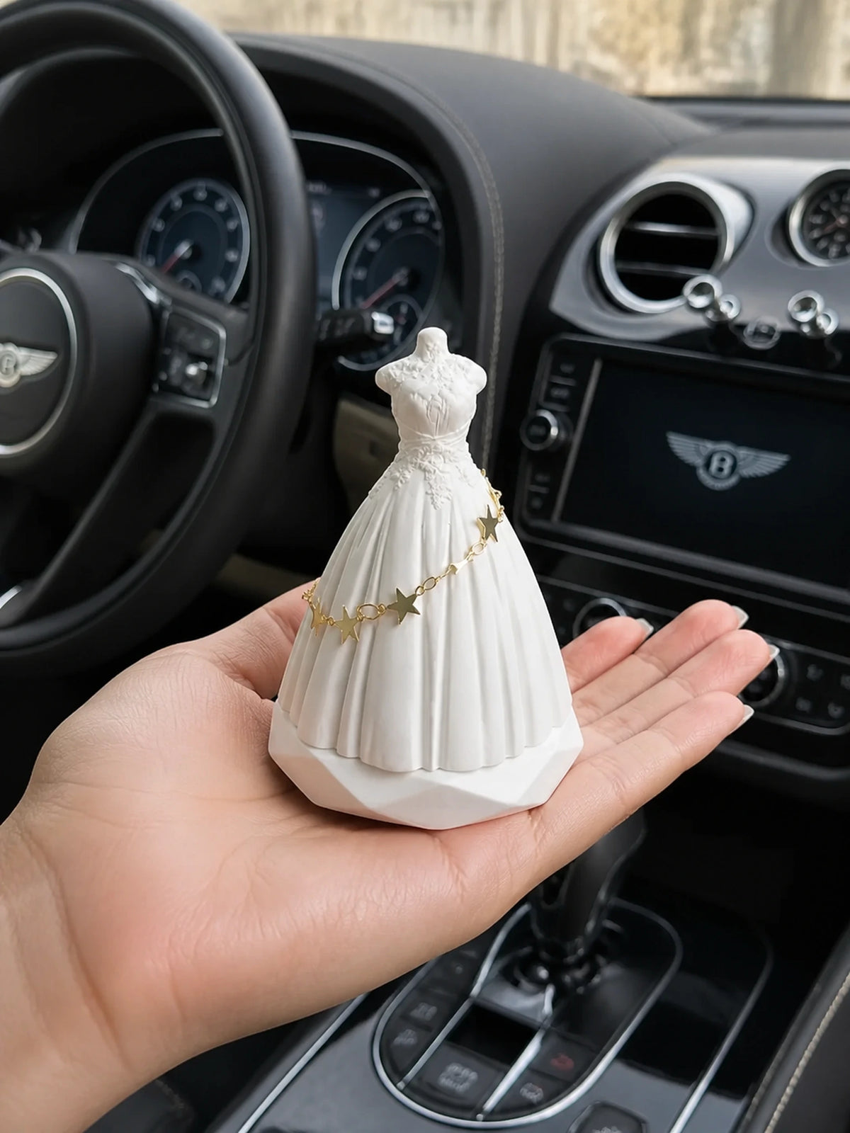 White bridal silhouette dashboard ornament shown in hand for scale