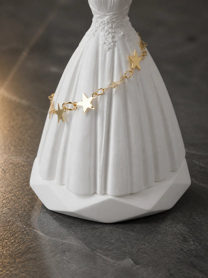 Close detail of the gold star chain, gown folds and stable ornament base
