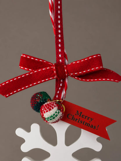 Close view of the red stitched ribbon, two tartan beads and festive tag