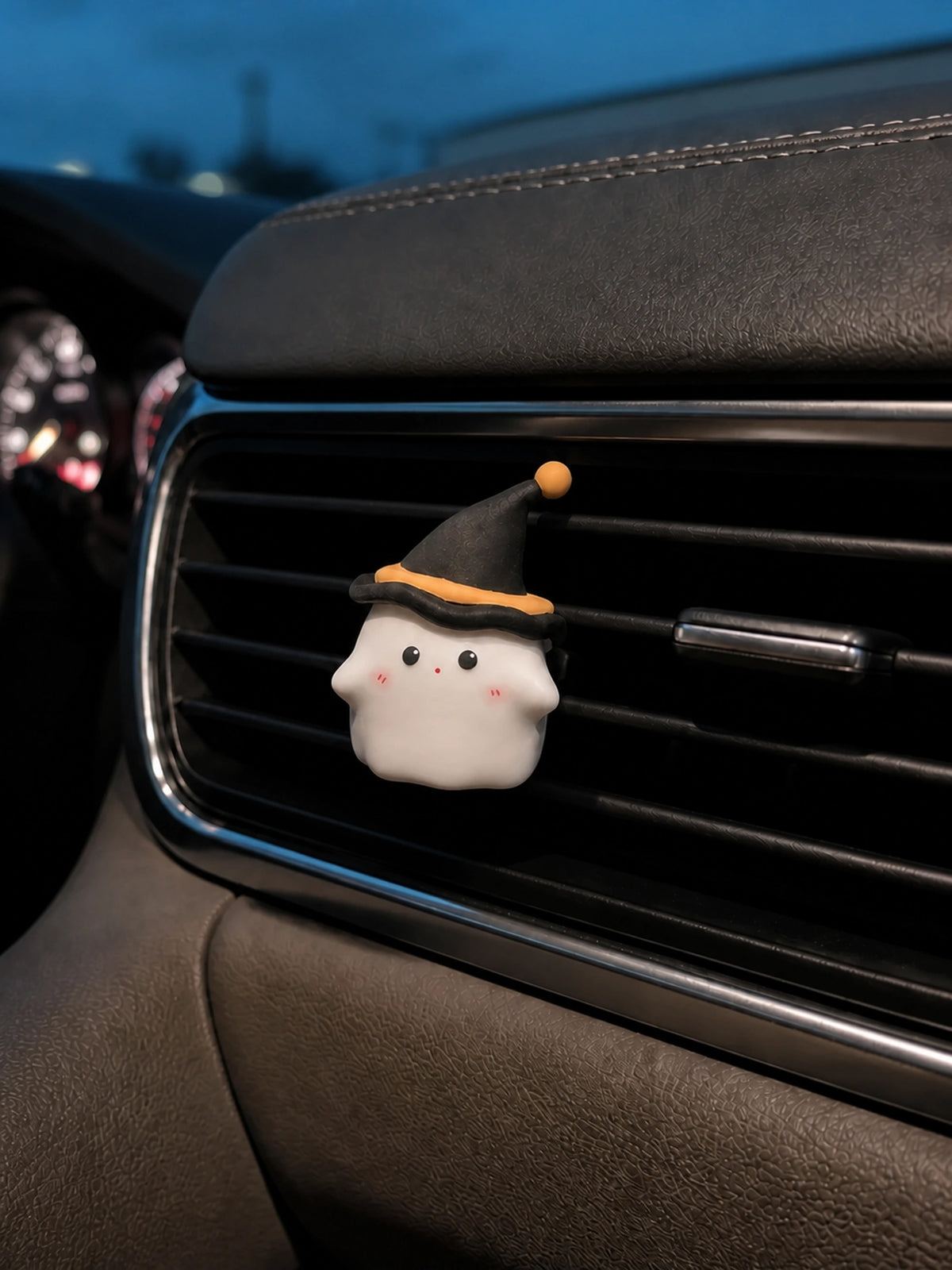 Midnight Ghost ornament installed on a horizontal car vent at blue hour