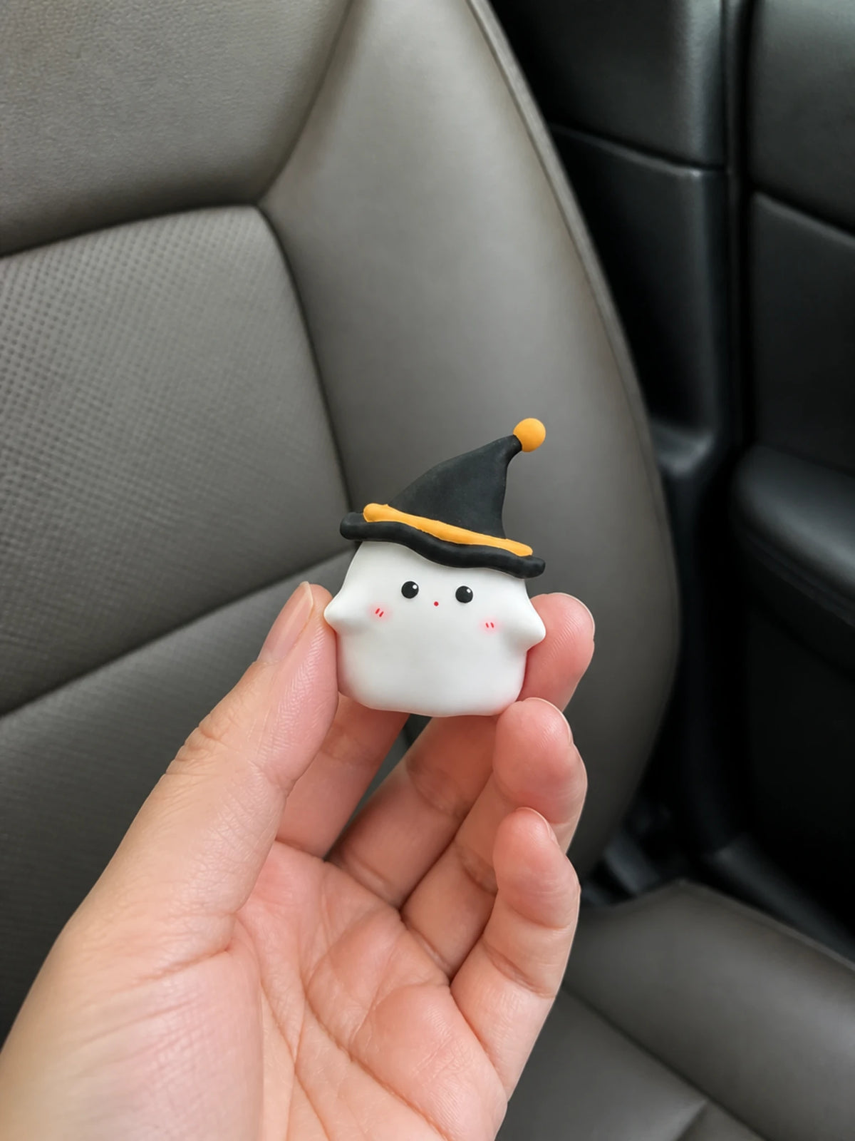 Midnight Ghost car vent ornament shown in hand for scale