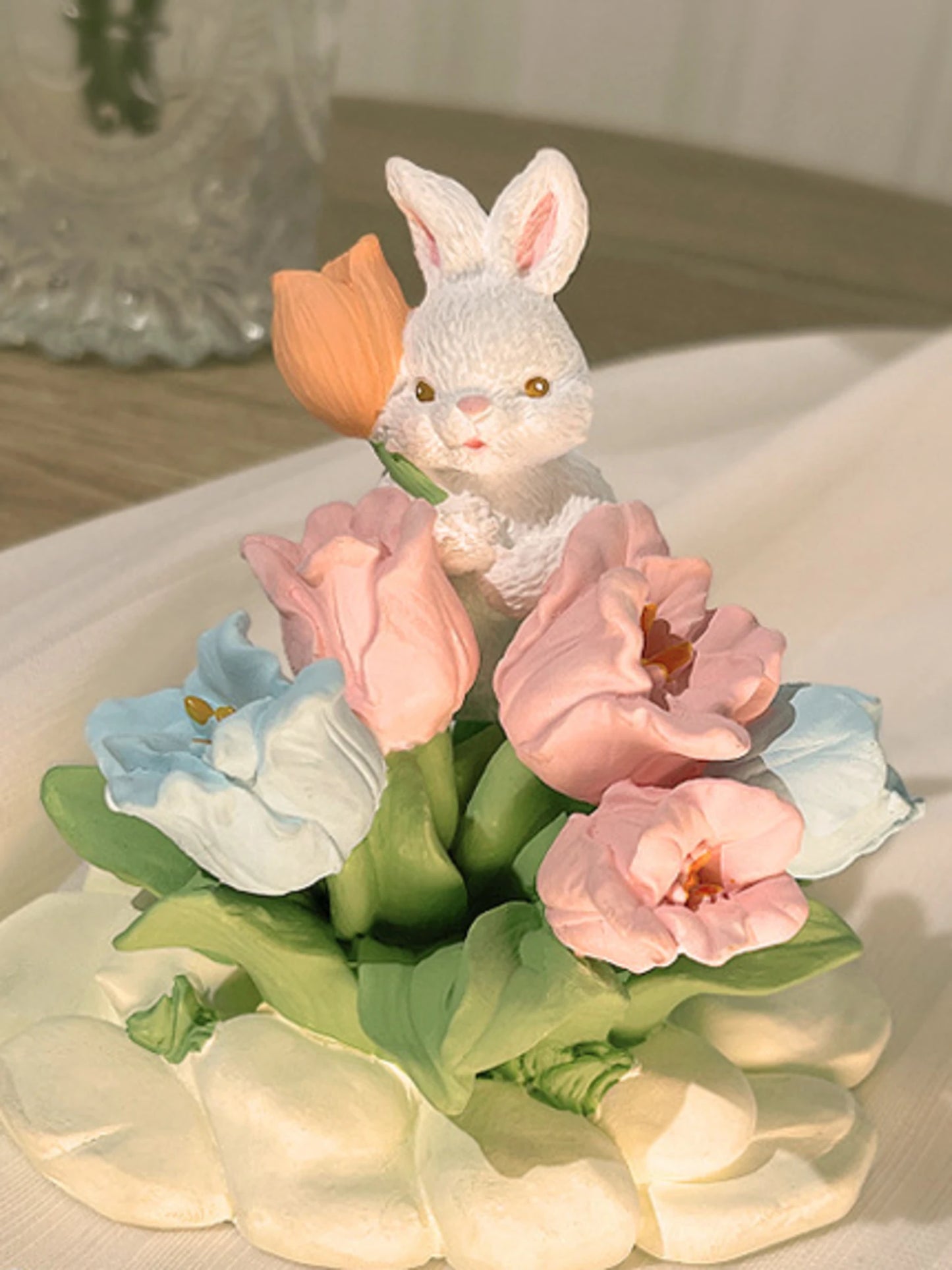 Close detail of the blue flowers, rabbit and sculpted garden base