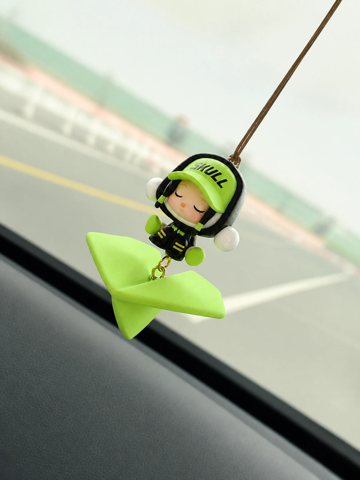 Green Wanderer Airplane Hanging Car Charm suspended beside a vehicle windshield