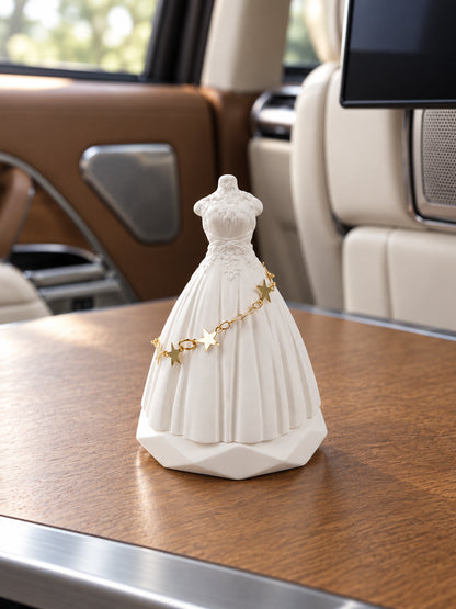 White bridal silhouette ornament on a level wood table in a parked Range Rover SV rear cabin