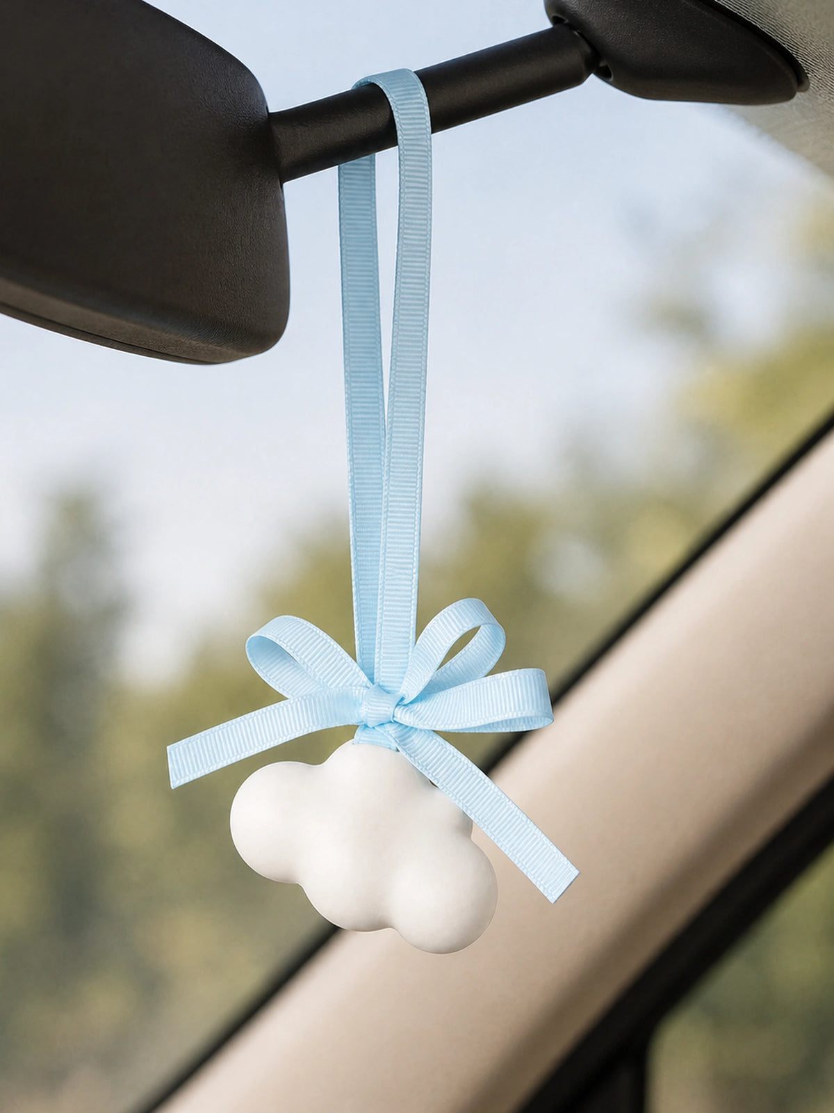 White cloud diffuser hanging inside car with beige interior