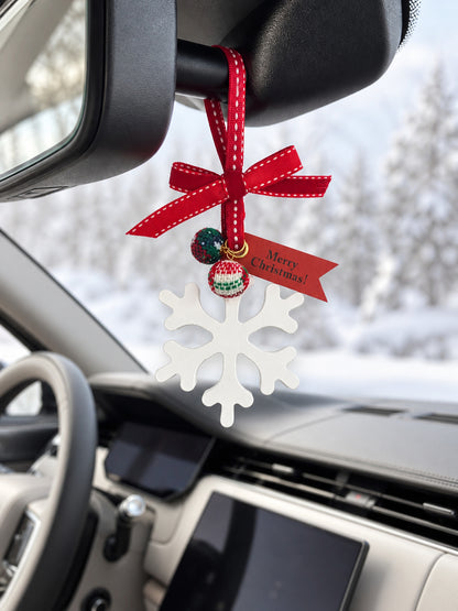 Winter snowflake ornament hanging from a ribbon loop behind the mirror in a parked Range Rover SV
