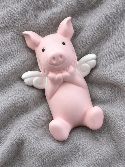Overhead view of the complete pink angel-wing Wish Pig resting on gray fabric; fabric not included
