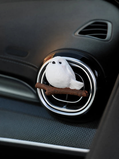 White chubby bird car air freshener clipped on black vent