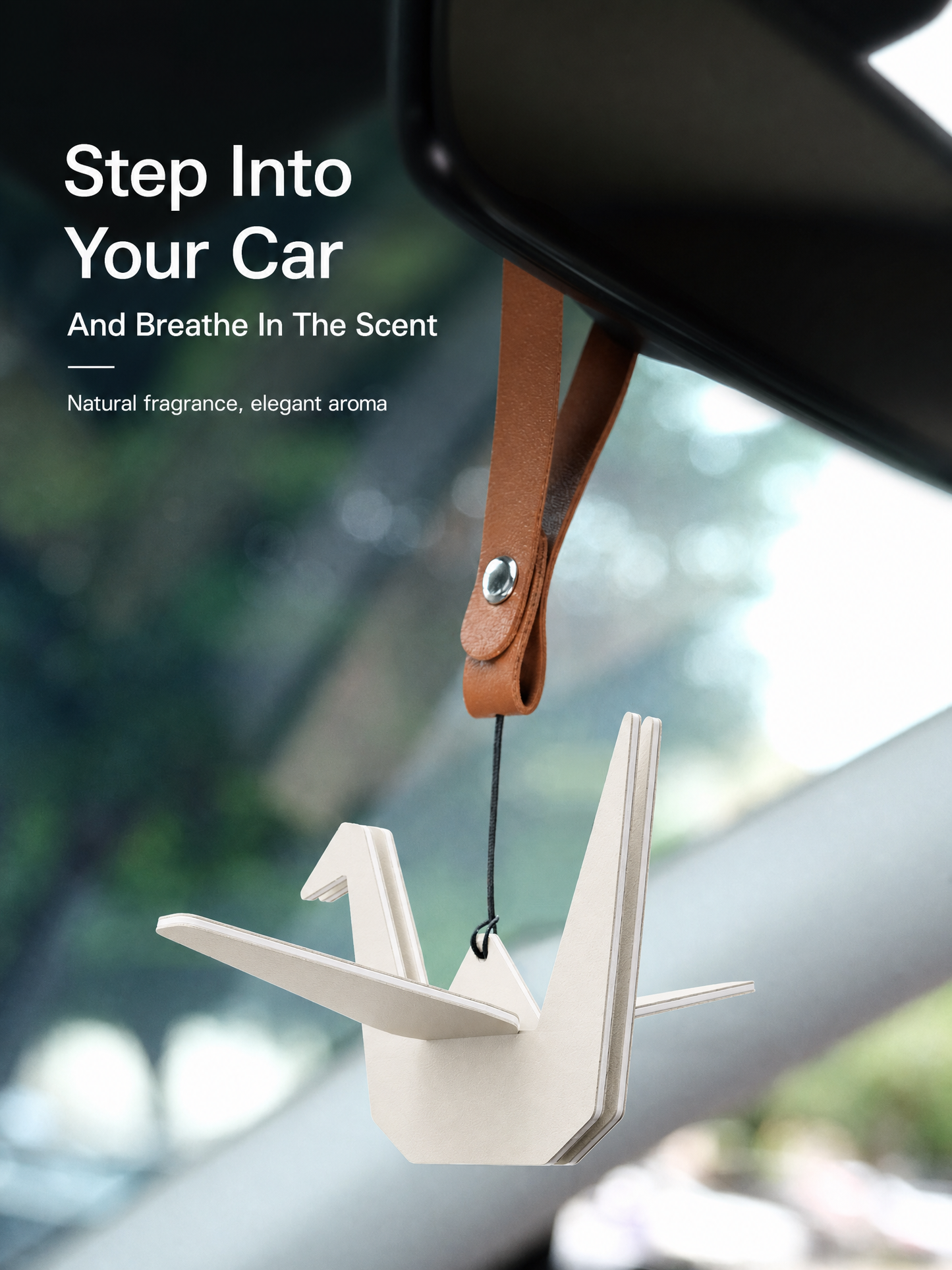 White origami crane air freshener hanging inside a beige car interior